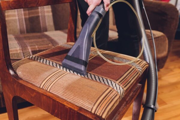 Proces prania tapicerki krzeseł za pomocą odkurzacza piorącego.
