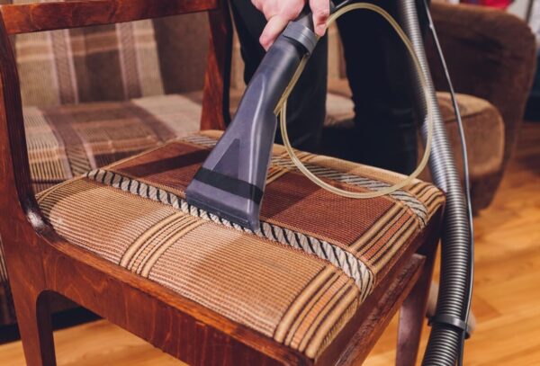 Proces prania tapicerki krzeseł za pomocą odkurzacza piorącego.