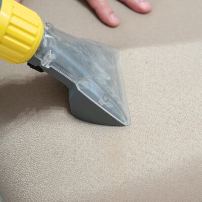 Pranie tapicerki krzeseł za pomocą specjalnego urządzenia czyszczącego.